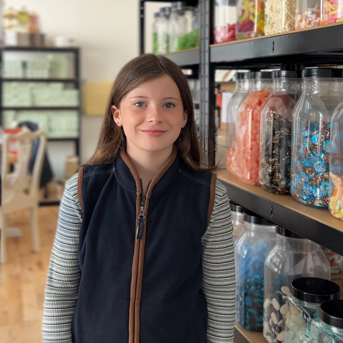 Woman standing in a store with shelves stocked with various products