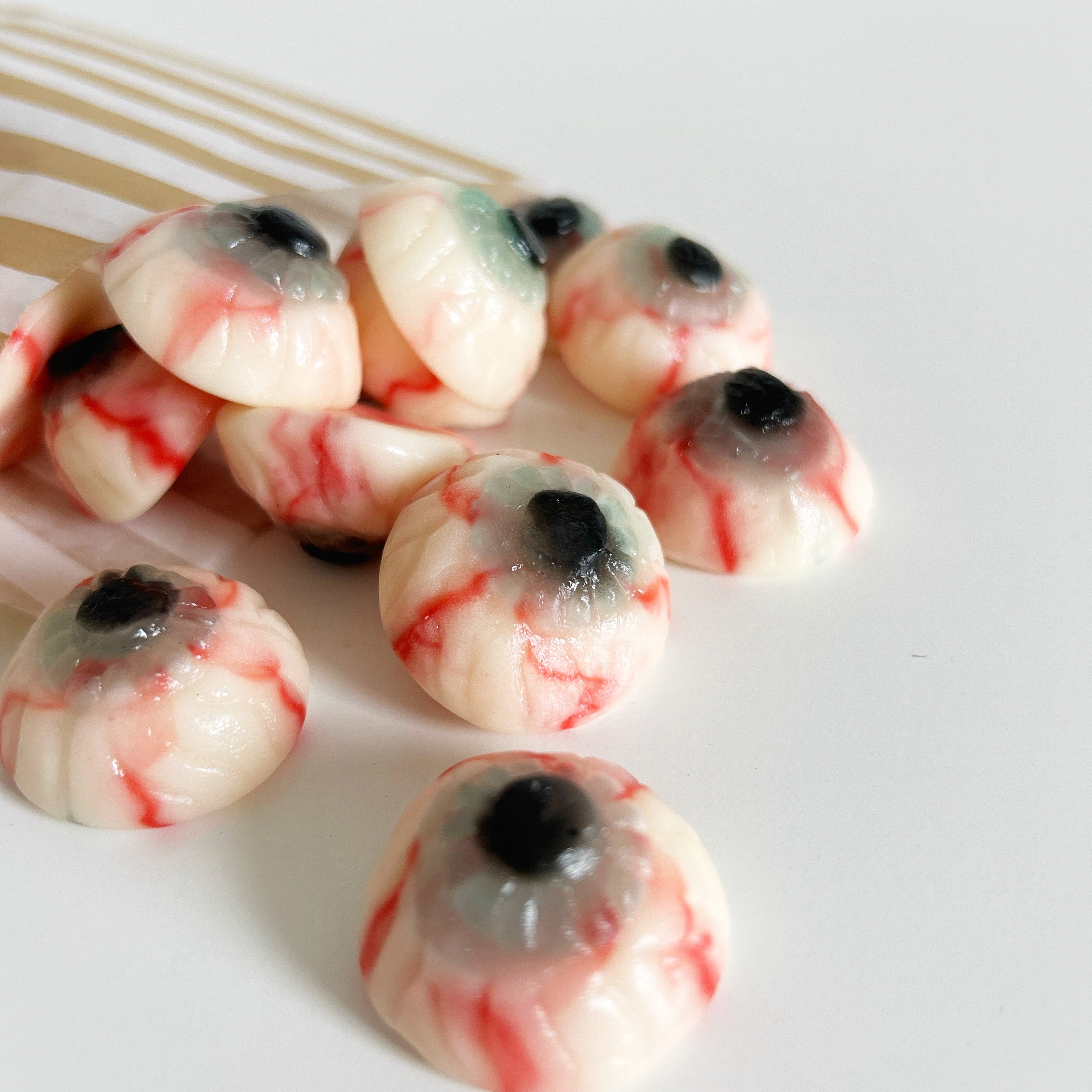 Eyeball-shaped candies with red and black details on a white background