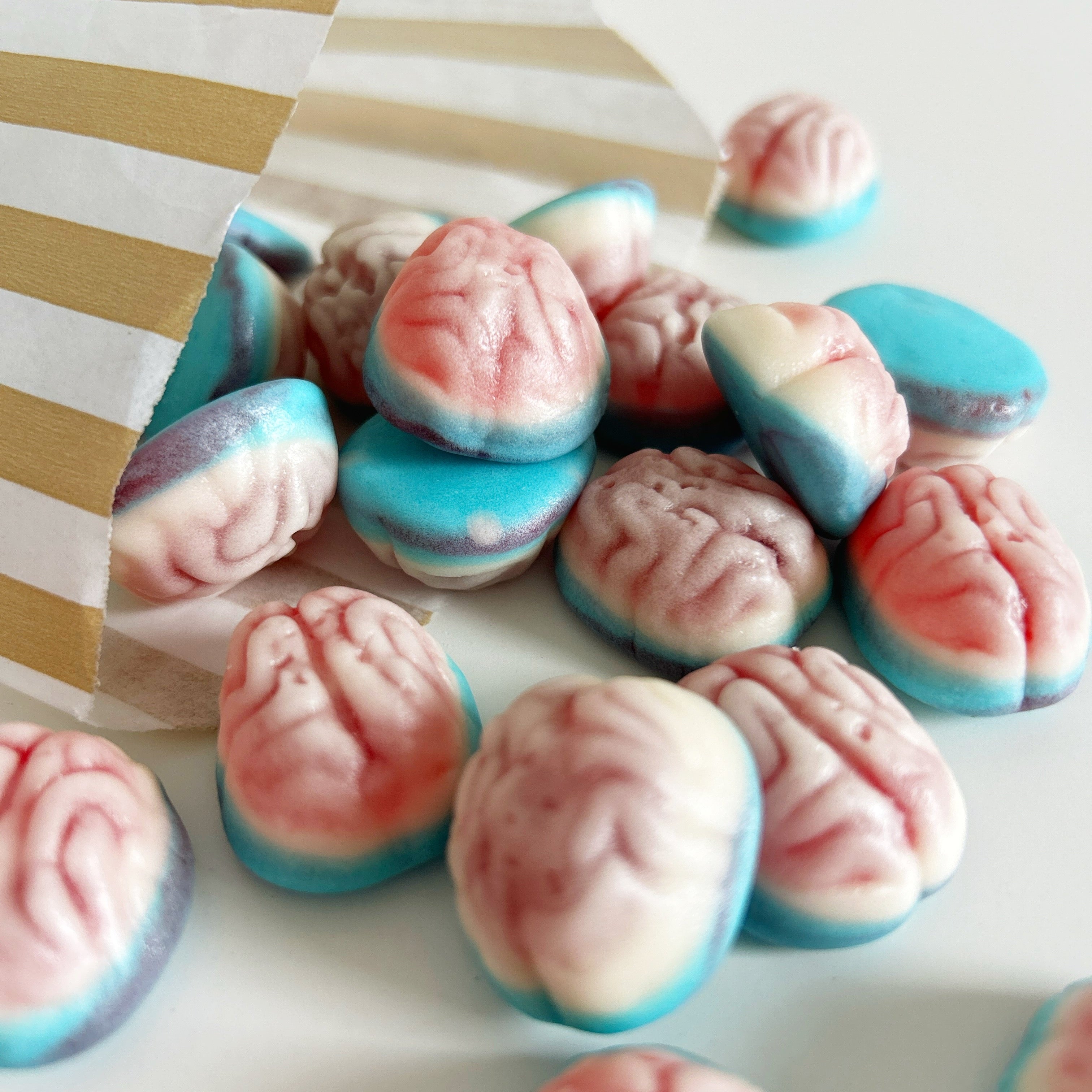 Colorful brain-shaped candies on a white and gold striped paper