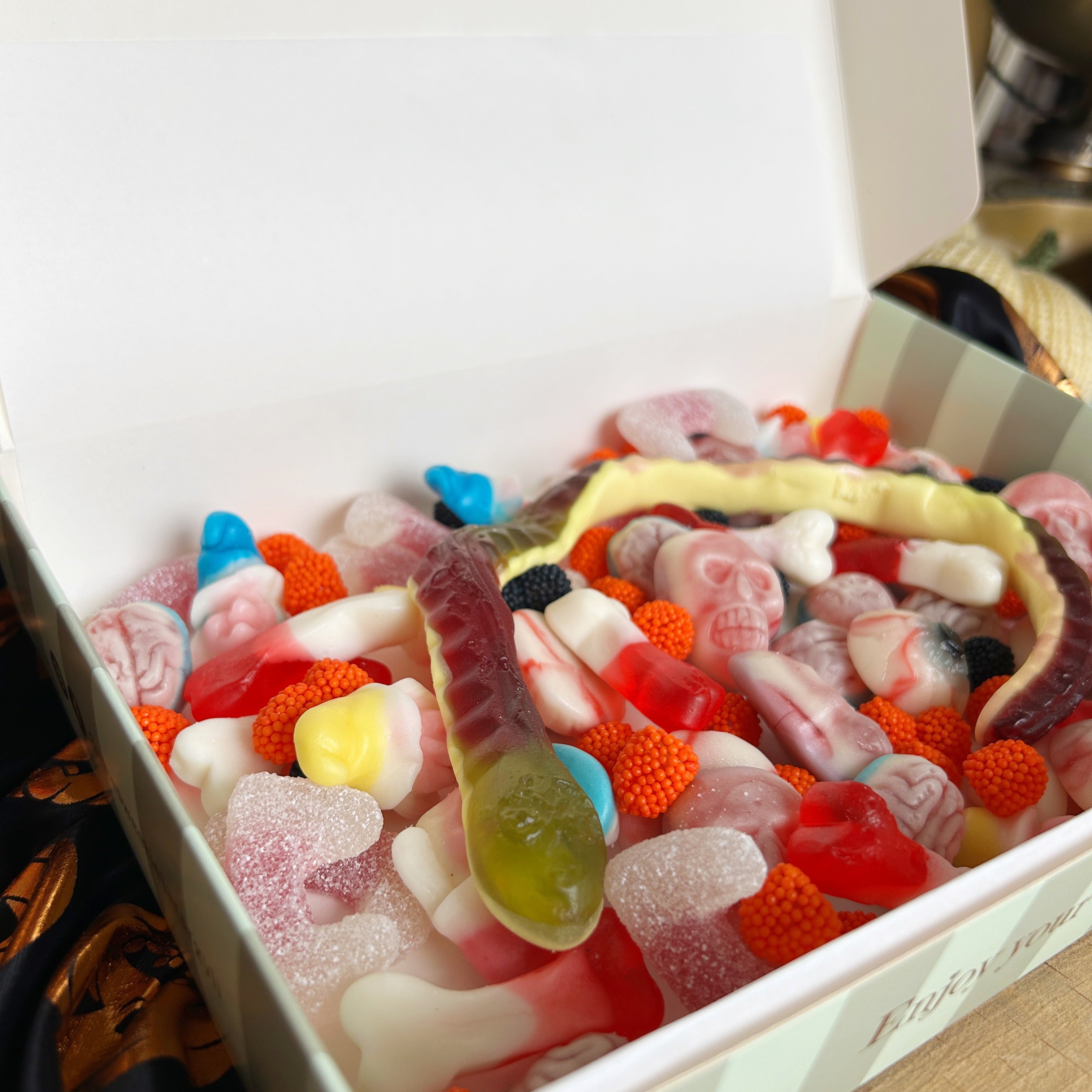 Box of assorted colorful gummy candies on a white background