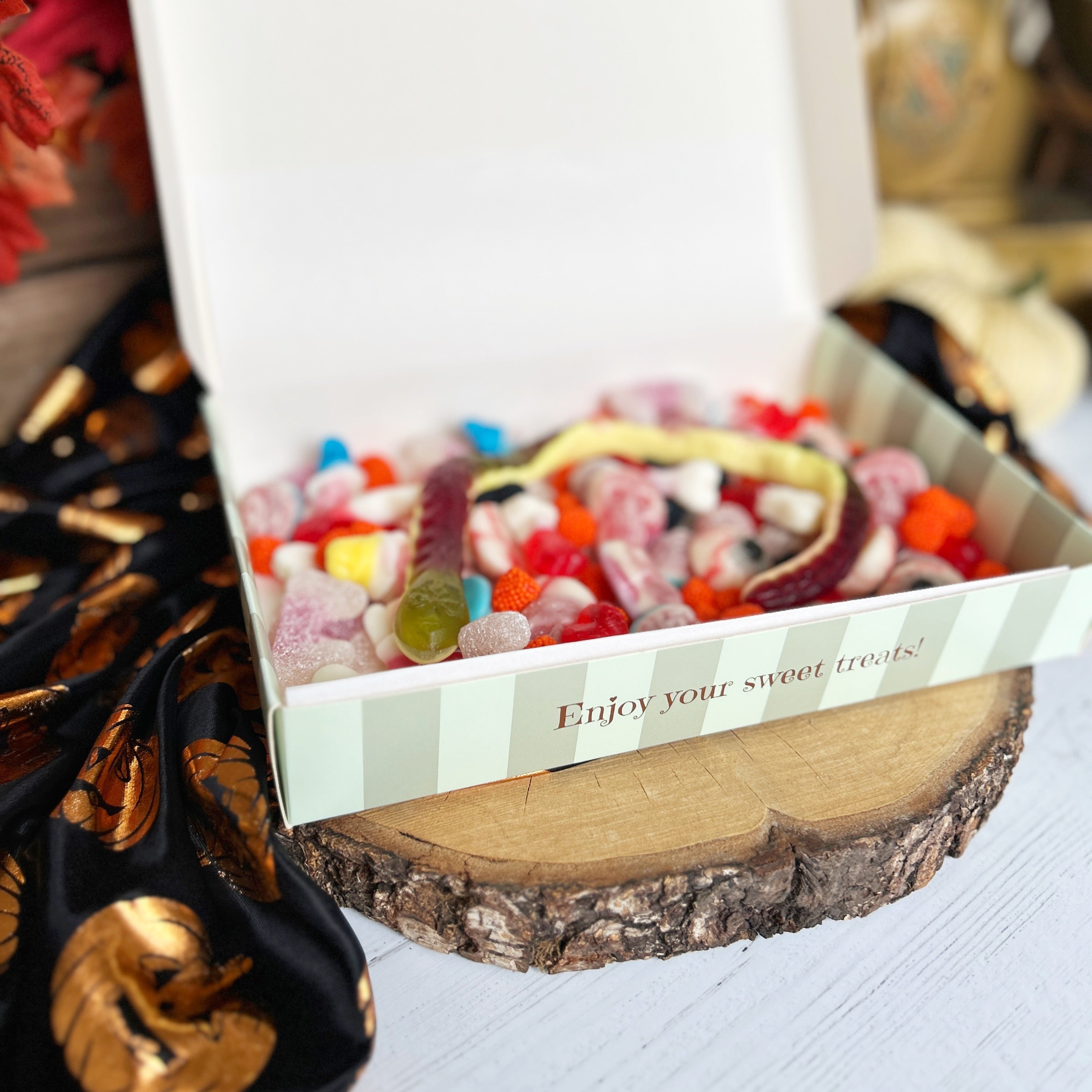 Box of gummy worms with a decorative background